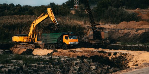 A closeup shot of an ongoing construction  with tracks and a bulldozer on an  abandoned land